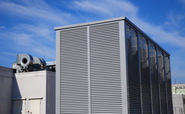 Industrial air conditioning and ventilation systems on the street against blue sky with white clouds