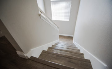 The interior of a newly remodeled staircase finished with a deep rich wood laminate.